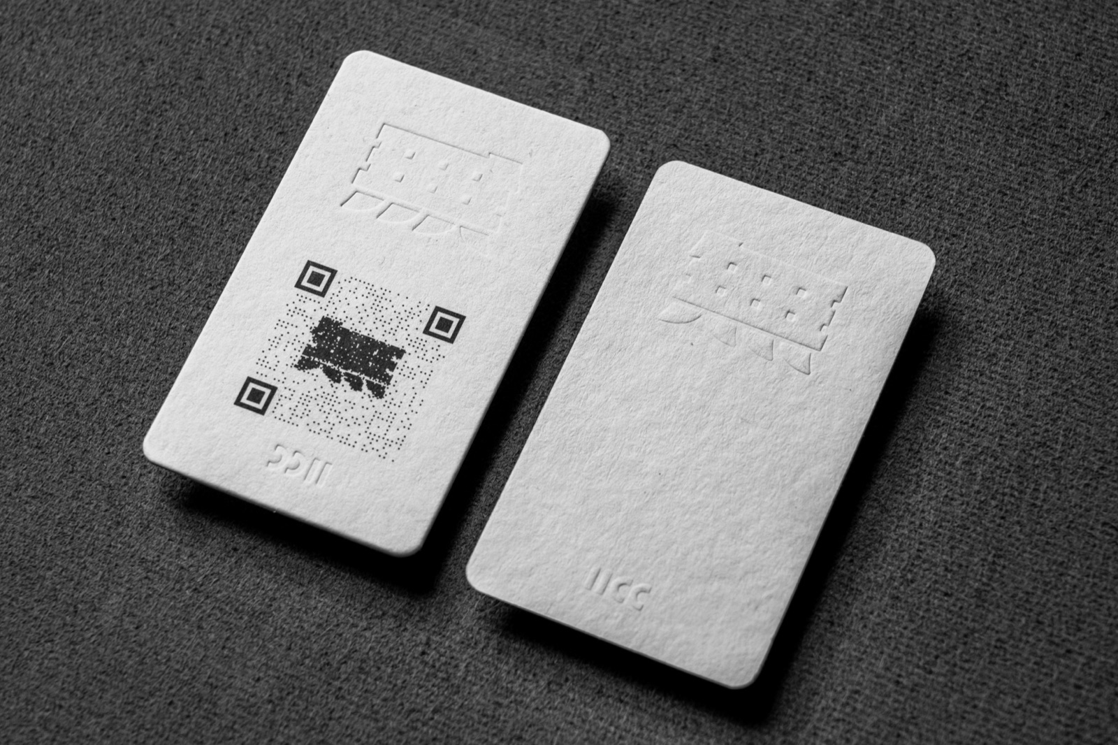 White rounded cards with a large geometric tone-on-tone relief on one face.