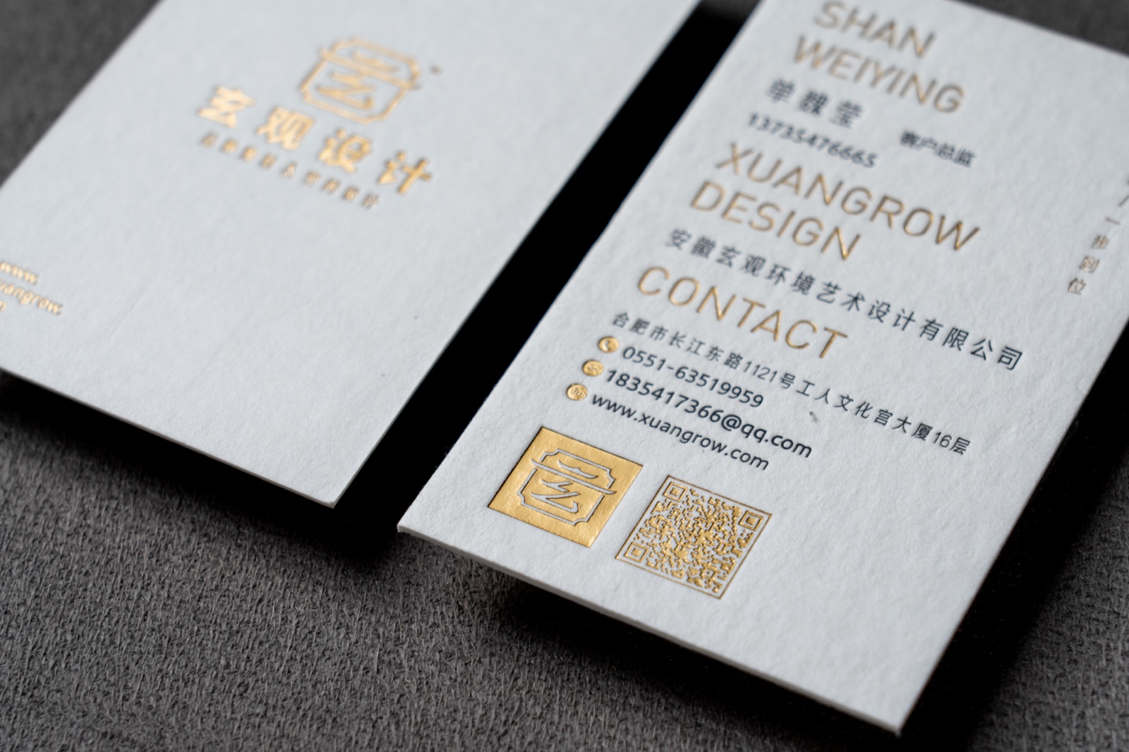 A close view of textured white cards with a small gold crest and mixed text sizes.