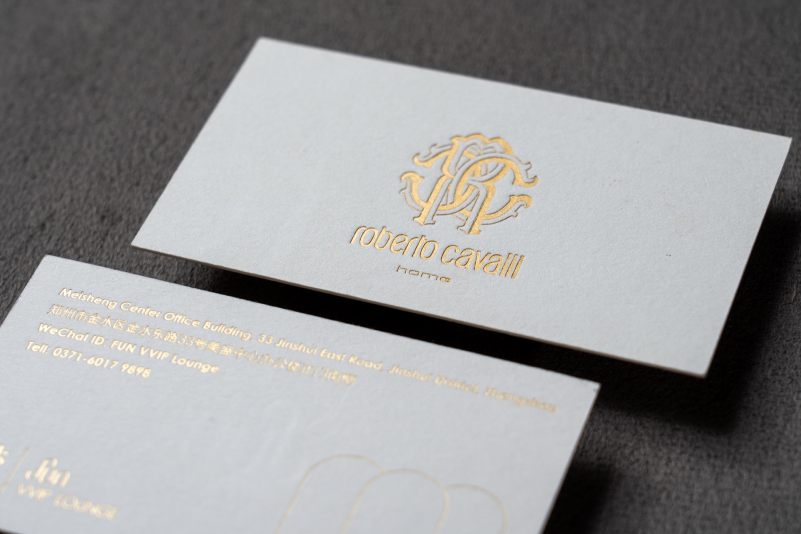 White cards with a reflective gold monogram and fine gold text.
