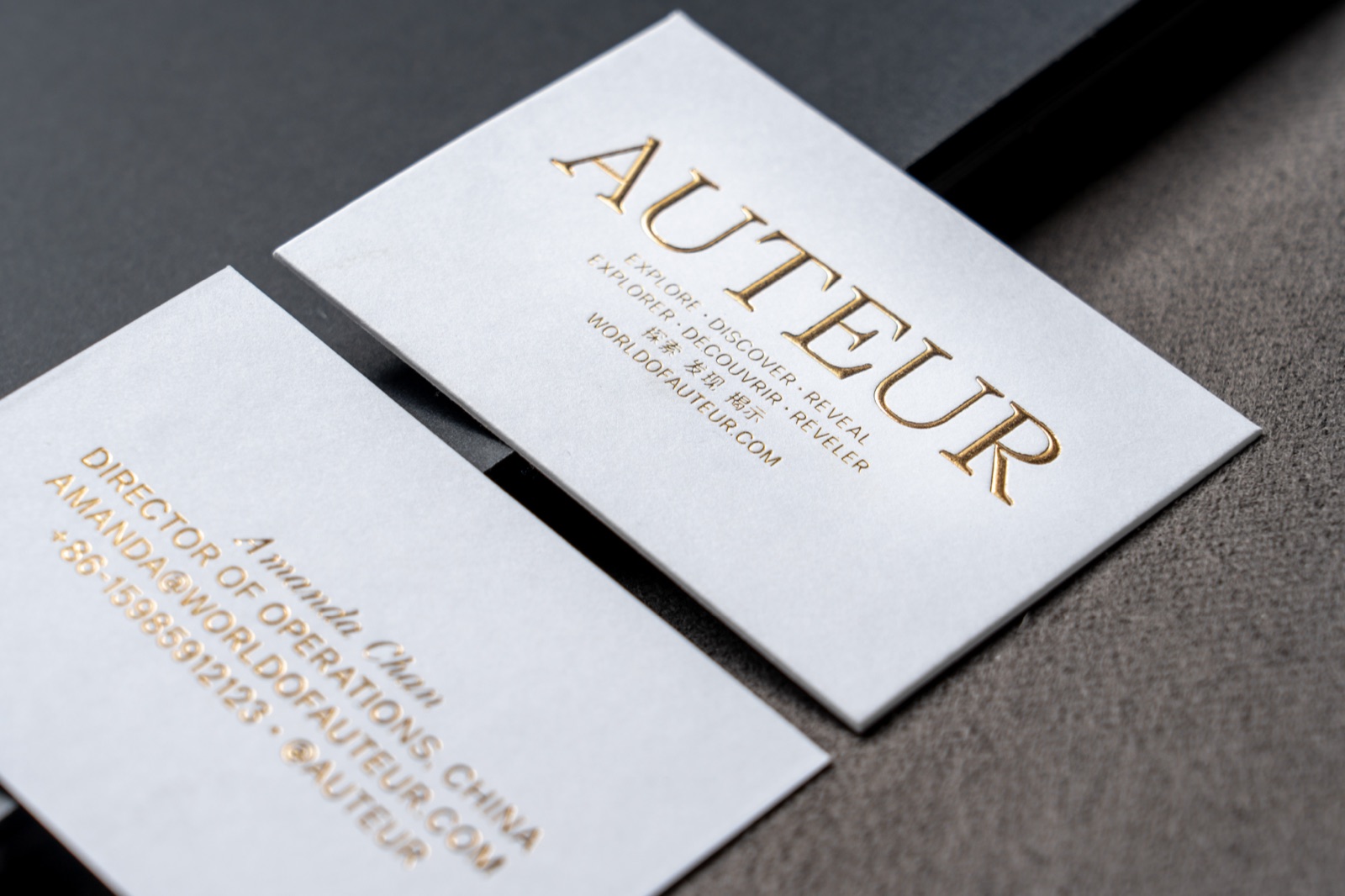 A white card pair with large reflective gold serif lettering.