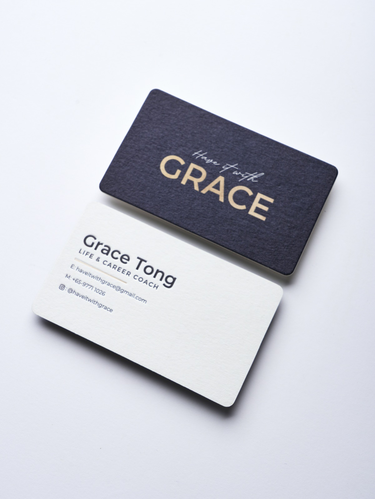 A black and white rounded card pair with a reflective gold name on the dark face.