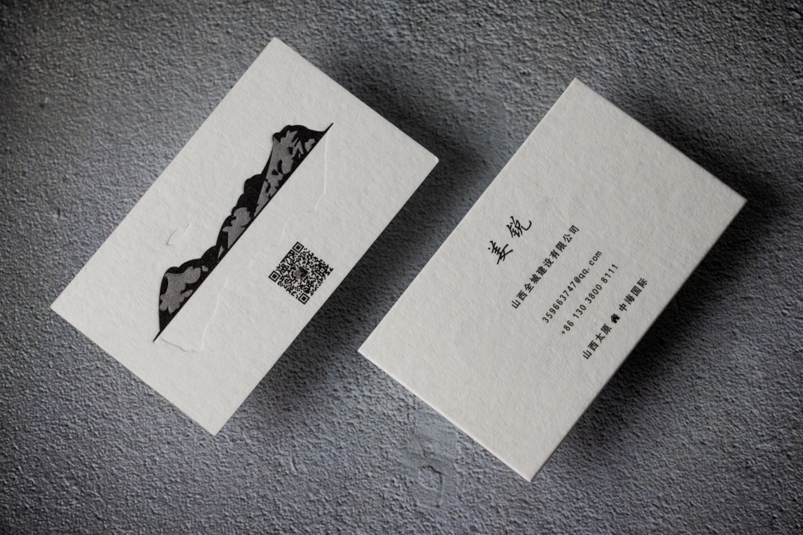 Textured pale cards with a black mountain illustration and vertical typography.