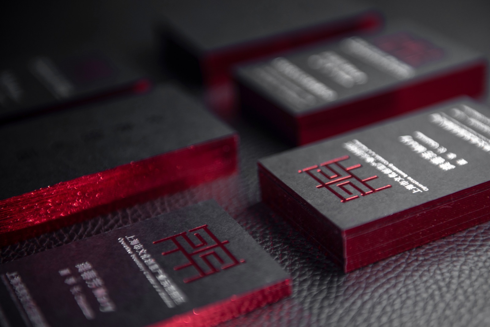 Dark card stacks with vivid red edges and light lettering on the faces.
