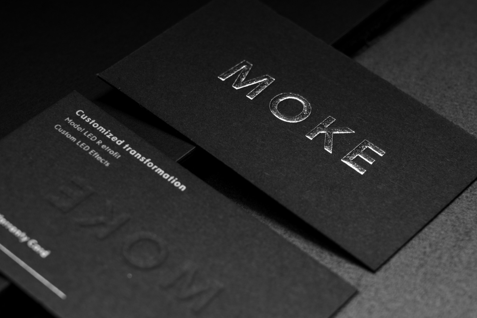 Dark textured cards with metallic silver lettering and subtle tone-on-tone type.