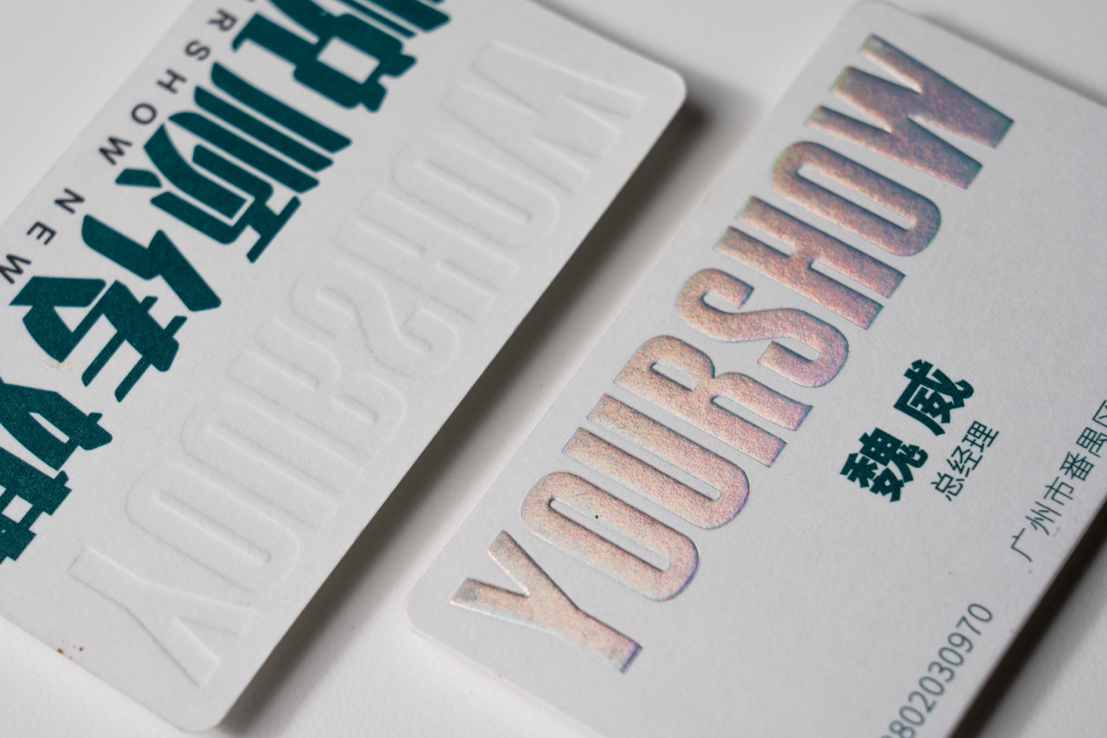 White cards with large reflective letters showing a range of metallic colours.