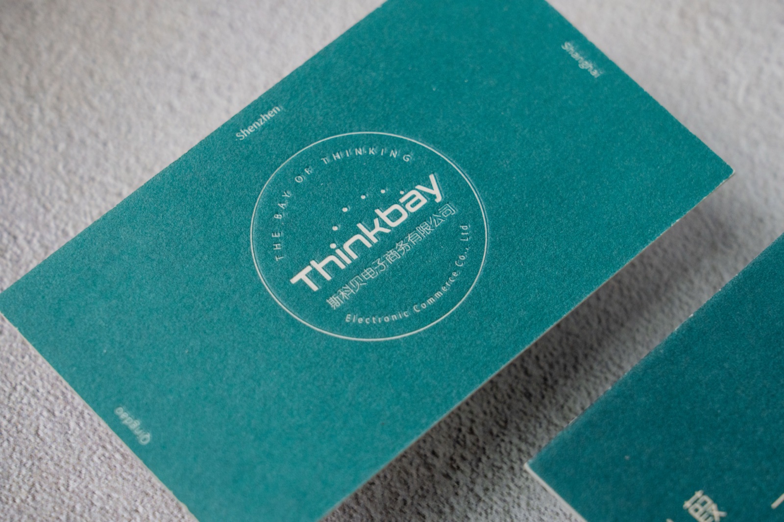 A close view of the small round mark and textured teal card surface.
