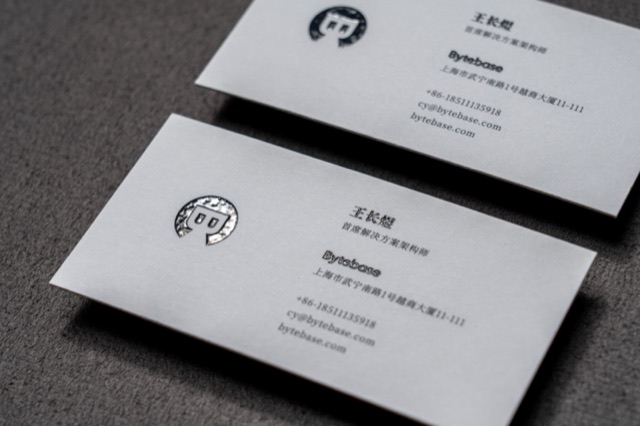 White cards with a small dark character illustration and neat contact text.