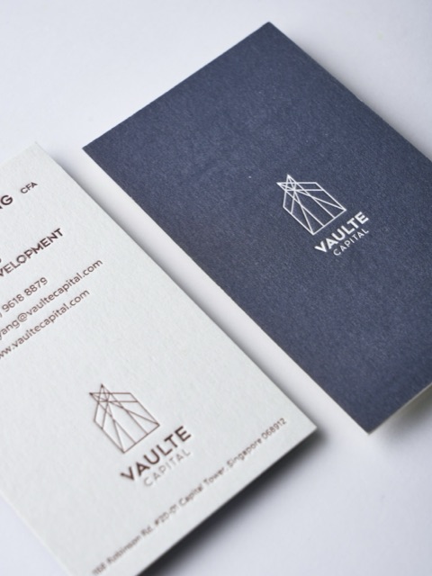 A navy and white business-card pair with a fine outlined emblem.