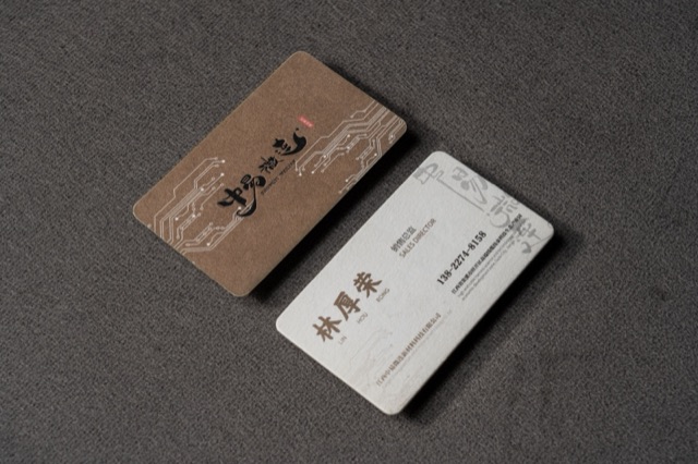 A brown card with a visible grain-like surface beside a pale companion card.