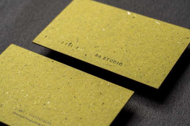 Yellow-green cards with visible flecks and fibres and a restrained dark inscription.