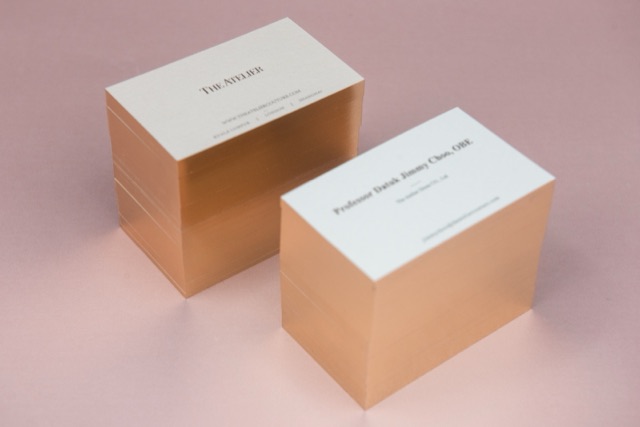 Two white card stacks photographed as tall columns with reflective copper-coloured edges.