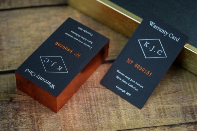 Navy cards and a stack with copper-coloured edges on a warm neutral surface.