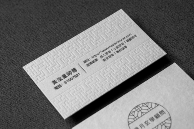 A pale card with a repeating geometric relief border and black central text.