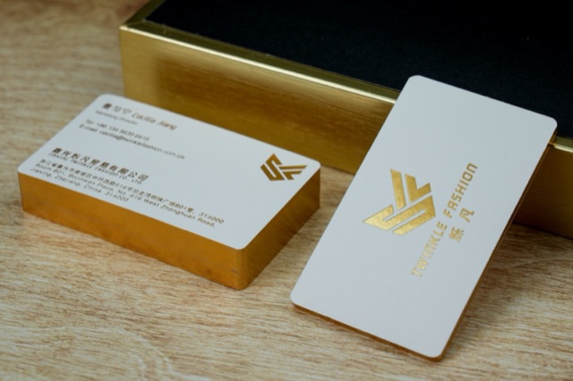 White cards and a stack with reflective gold-coloured edges.