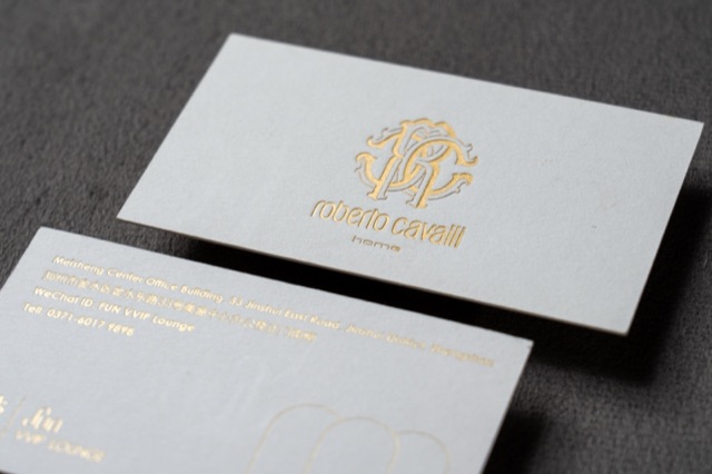 White cards with a reflective gold monogram and fine gold text.