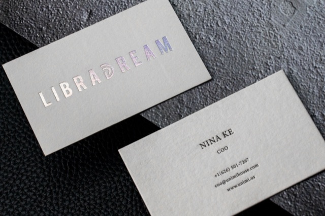 A light card pair with a wordmark reflecting several metallic colours.