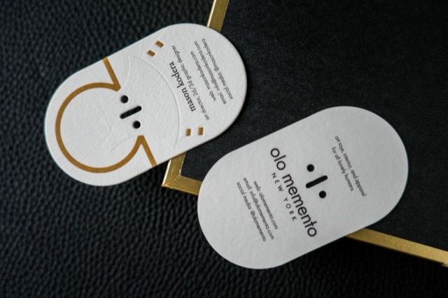 Two elongated rounded cards with a gold outline illustration and black contact text.