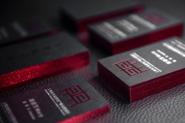 Dark card stacks with vivid red edges and light lettering on the faces.