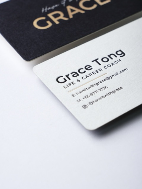 A close view of overlapping black and white cards with rounded corners and a gold-coloured name.