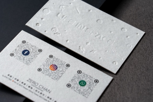 A light card pair combining many tone-on-tone relief symbols with small coloured details.